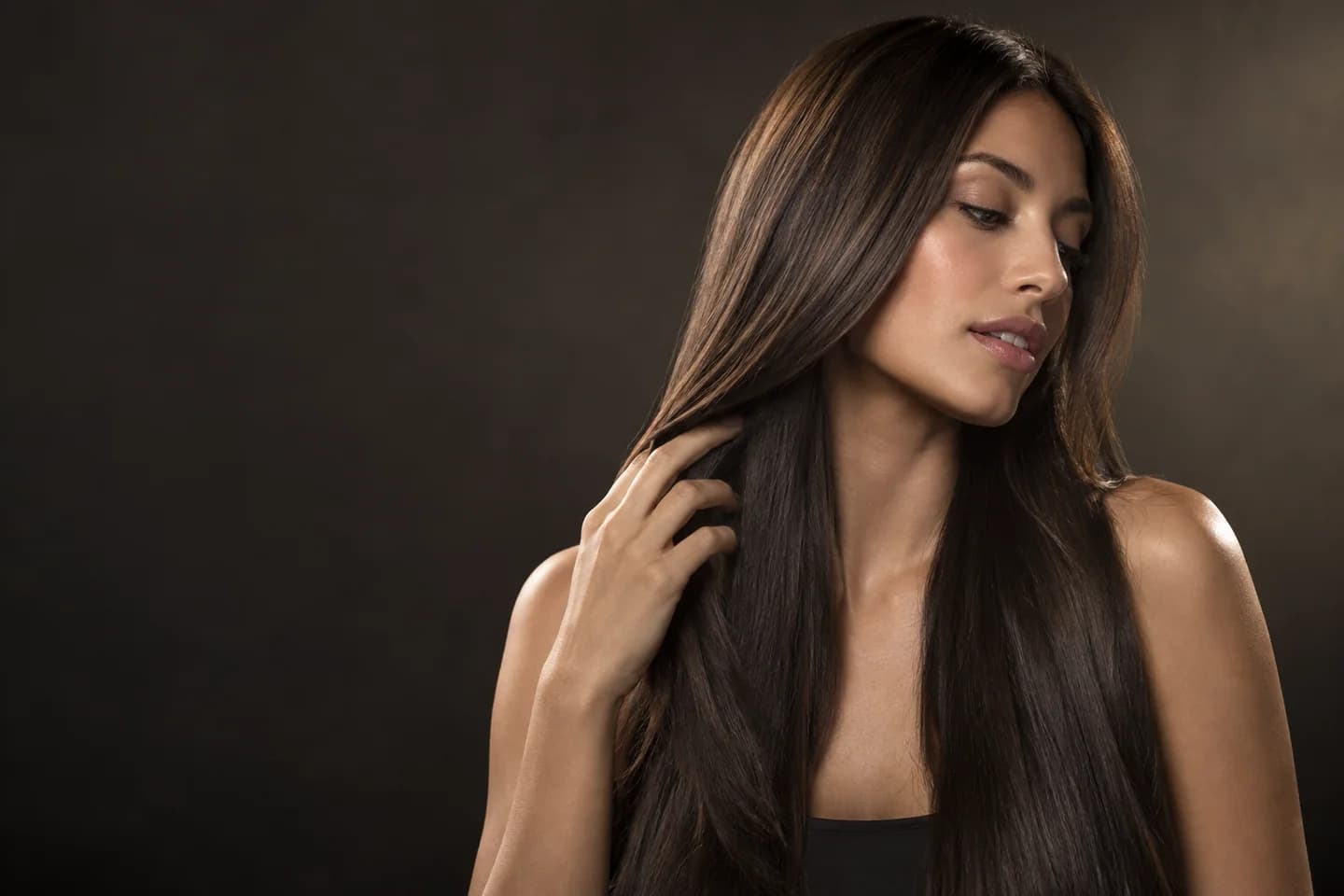 Woman with long smooth straight hair in soft studio light